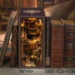 Illuminated Alchemy Master book nook displayed among vintage books, featuring miniature wizards, potion bottles, wooden balconies, a telescope, shelves and magical workshop details.