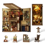 Structure and miniature accessories display of the World in a Frame book nook, featuring a two-level art studio, illuminated finished model, easel, gramophone, display shelf, rocking chair and side table.