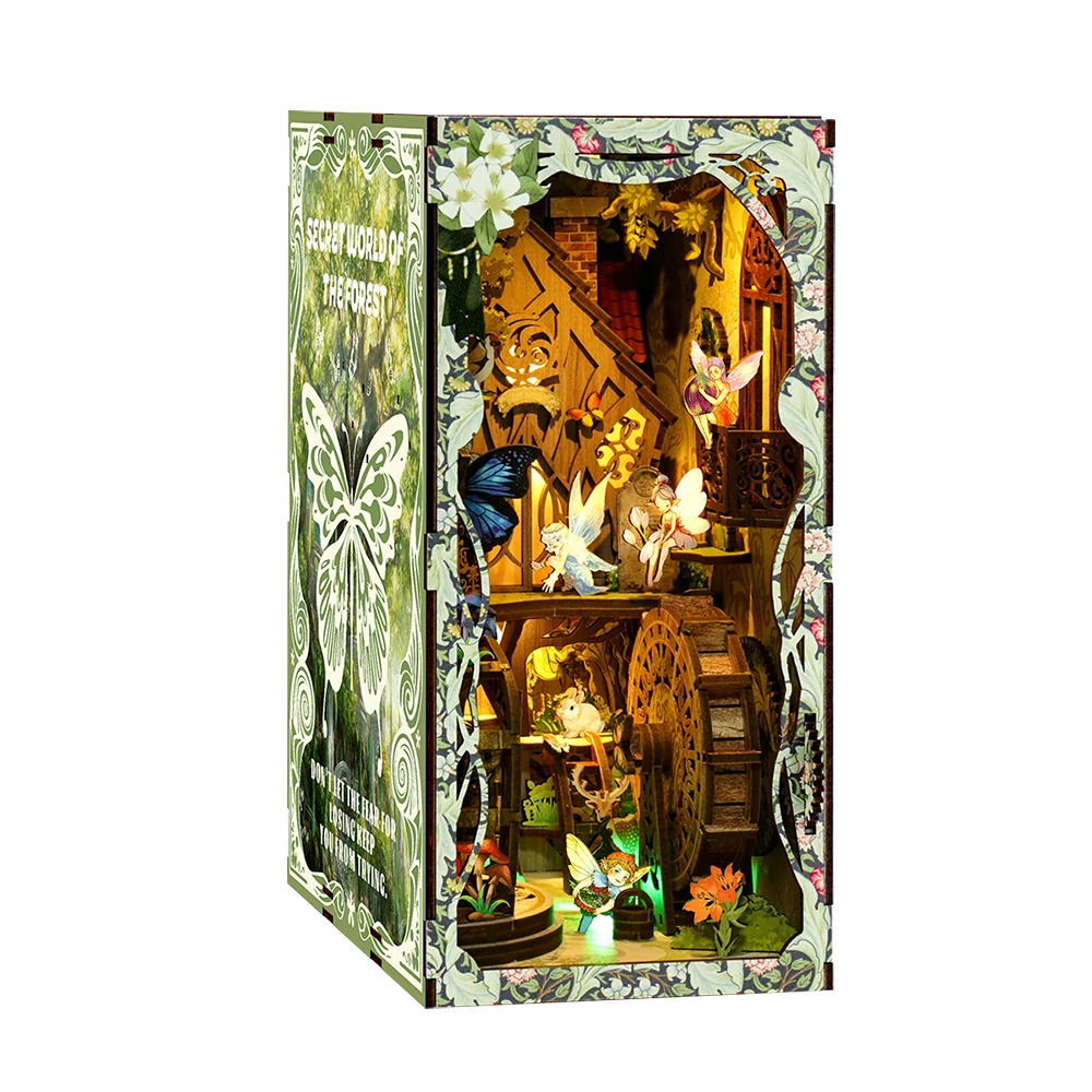 Illuminated angled view of the Forest Enigma book nook, featuring fairy figures, butterflies, a wooden water wheel, floral patterns, a treehouse-style interior and glowing miniature forest details.