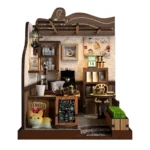 Front view of the completed Country Cafe DIY miniature featuring a coffee bar, espresso machine, pour-over coffee set, shelves, dining table, menu board, planter, and decorative cat.