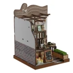 Side-angle view of the completed Country Cafe DIY miniature featuring a coffee table, pour-over set, menu board, shelves, brick wall, planter, and decorative cat.