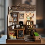 Front view of the completed Country Cafe DIY miniature featuring a coffee bar, espresso machine, pour-over coffee set, shelves, dining table, menu board, planter, and decorative cat.