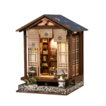 Angled front view of the illuminated Zen Mooslaterne DIY kit, featuring a Japanese house, Zen garden, bonsai, stone lantern, and miniature tea room.