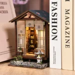 DIY Zen moss lantern book nook kit featuring an illuminated Japanese house, Zen garden, bonsai, stone lantern, and miniature interior details.