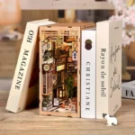 DIY Japanese Alley with Cat book nook kit, featuring an illuminated Japanese alleyway, miniature shops, lanterns, plants, and decorative cats.