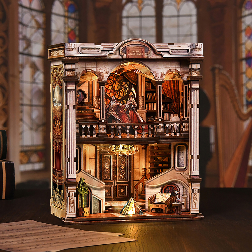 Illuminated front view of the Dream Opera House DIY kit, featuring an opera stage, miniature figures, staircases, a lamp, and detailed furniture.